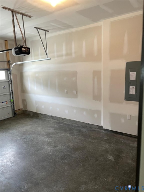 Garage featuring a garage door opener and electric panel