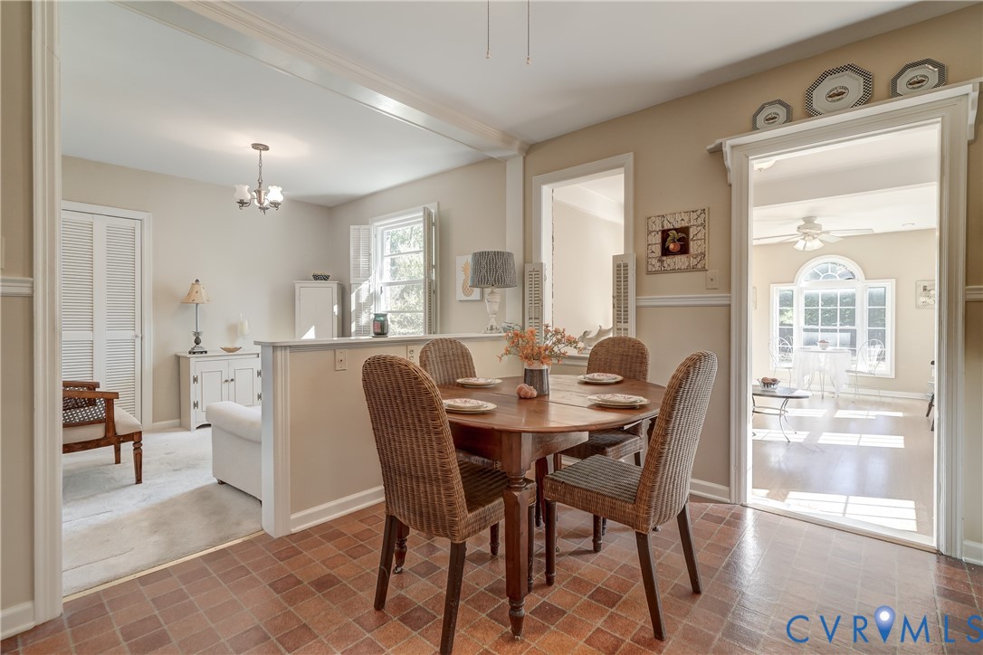 Dining area featuring ceramic tile flooring, chair rail molding, and a partial wall divider