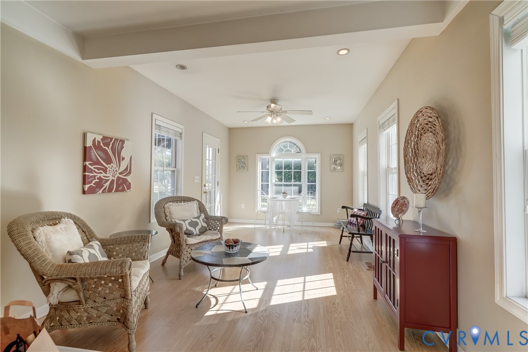 Sunroom featuring wood-finish flooring, an arched window, a ceiling fan, and recessed lighting
