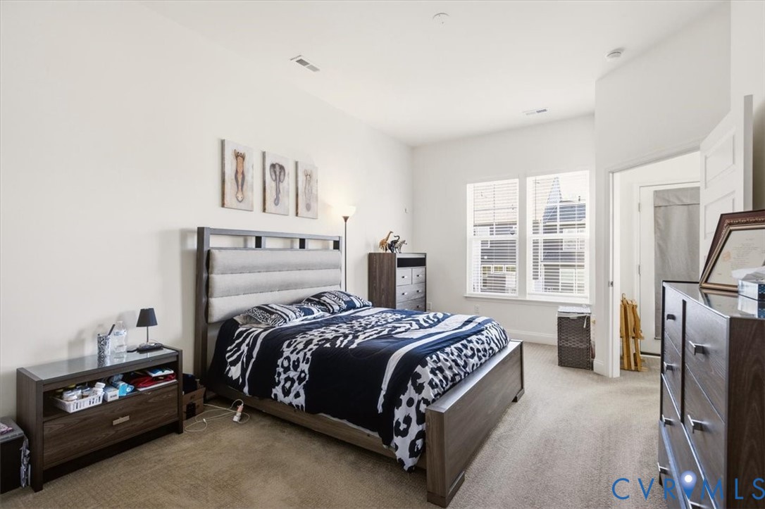 Neutral interior space featuring high ceilings, wall-to-wall carpeting, and double-pane windows