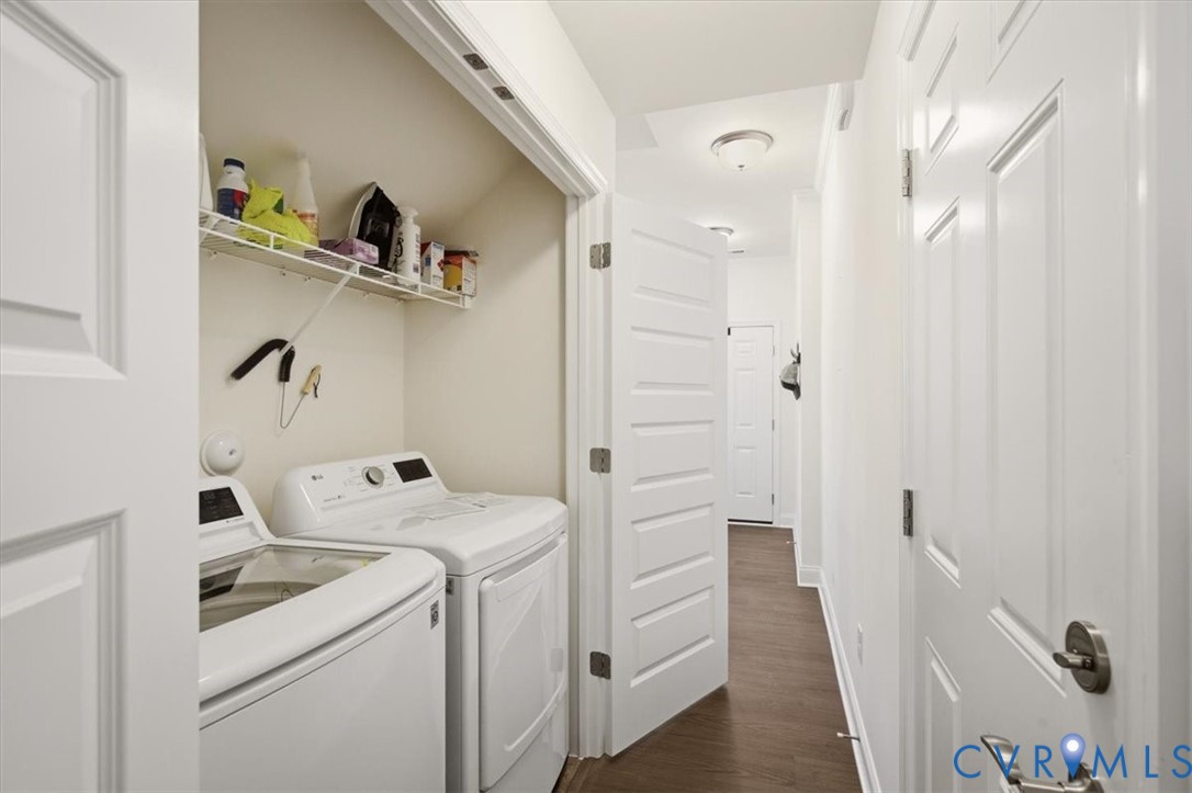 Laundry closet featuring built-in wire shelving, white panel doors, and wood-finish flooring