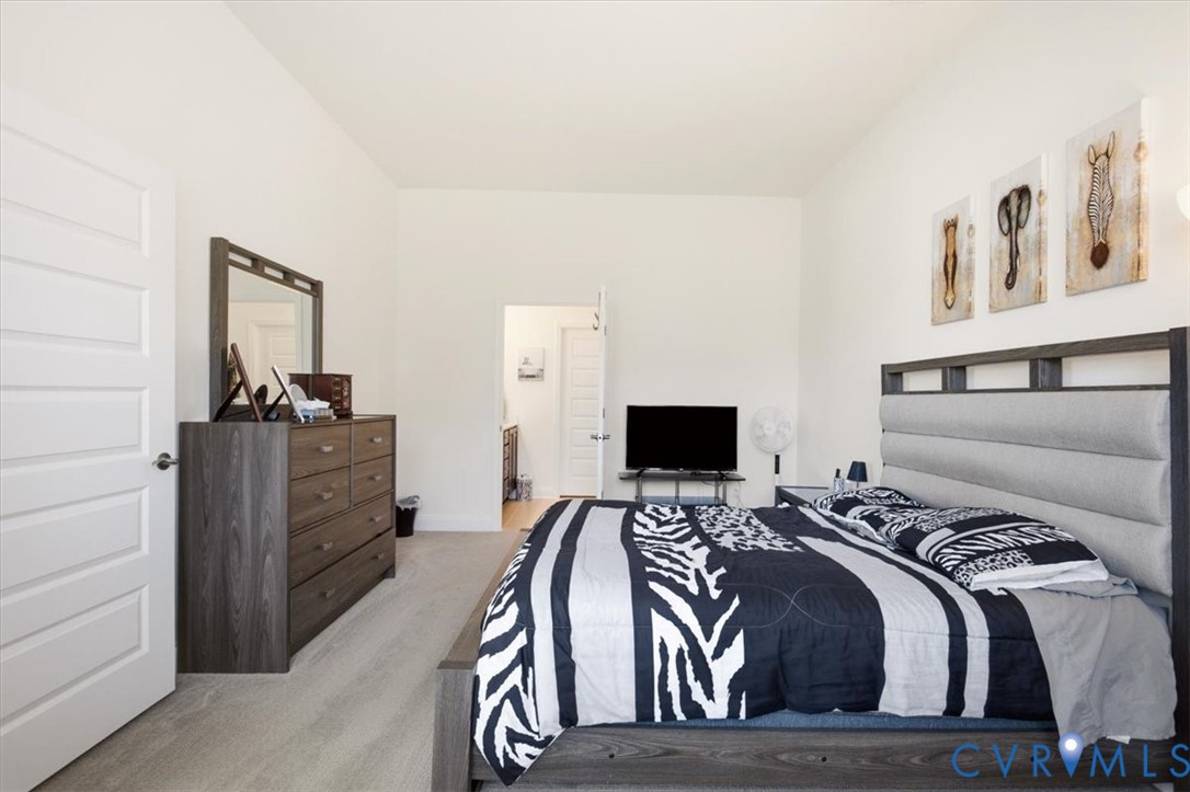 Neutral-toned interior featuring high ceilings, light-finish flooring, and a multi-panel door