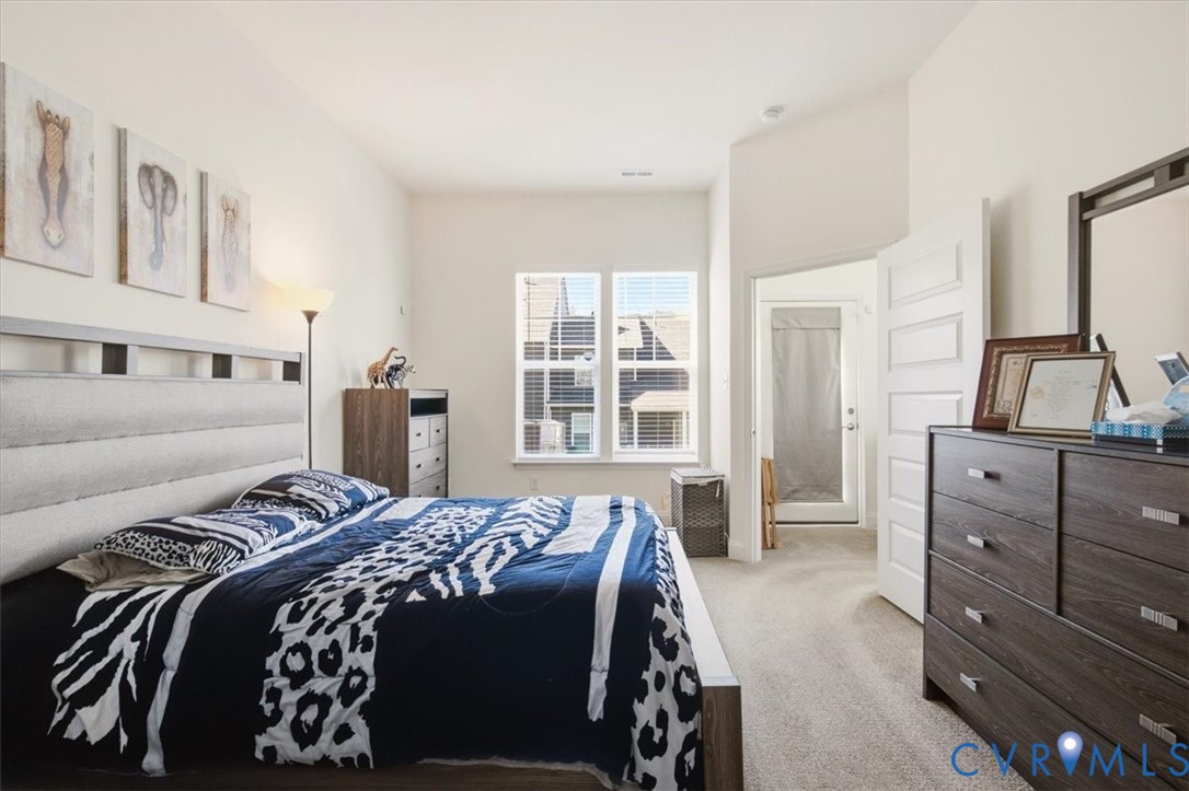Neutral-toned room featuring high ceilings, neutral carpeting, and a multi-panel interior door