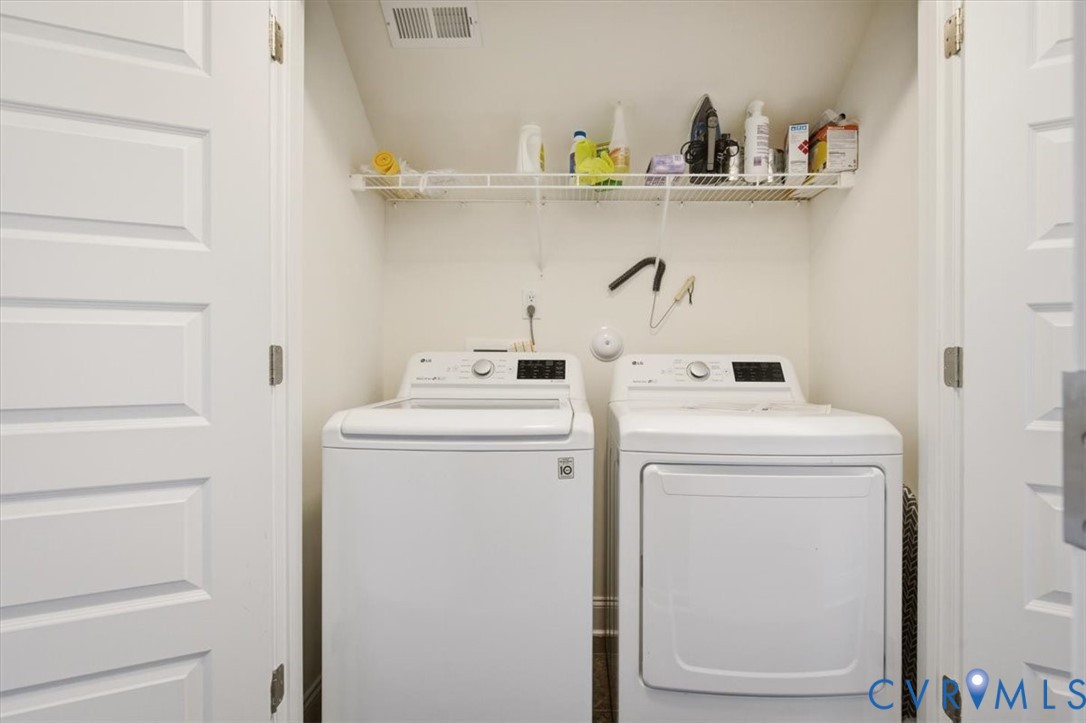 Laundry alcove featuring white paneled double doors and overhead wire shelving