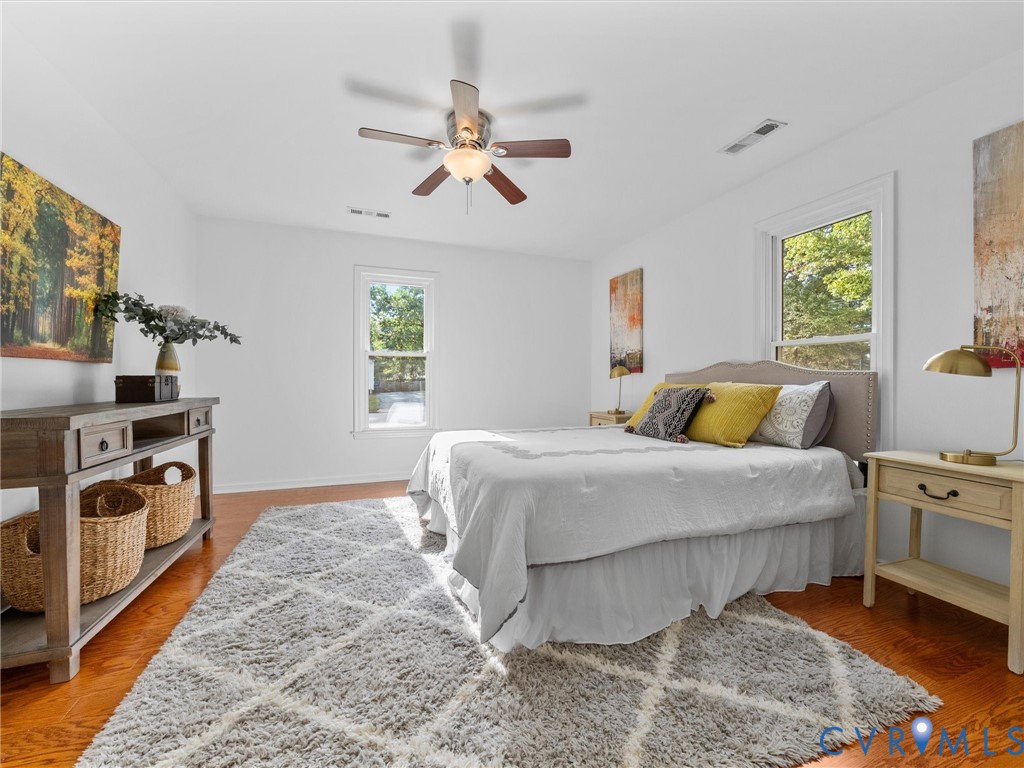 Wood-finish flooring, dual windows with natural light, and ceiling fan with integrated lighting
