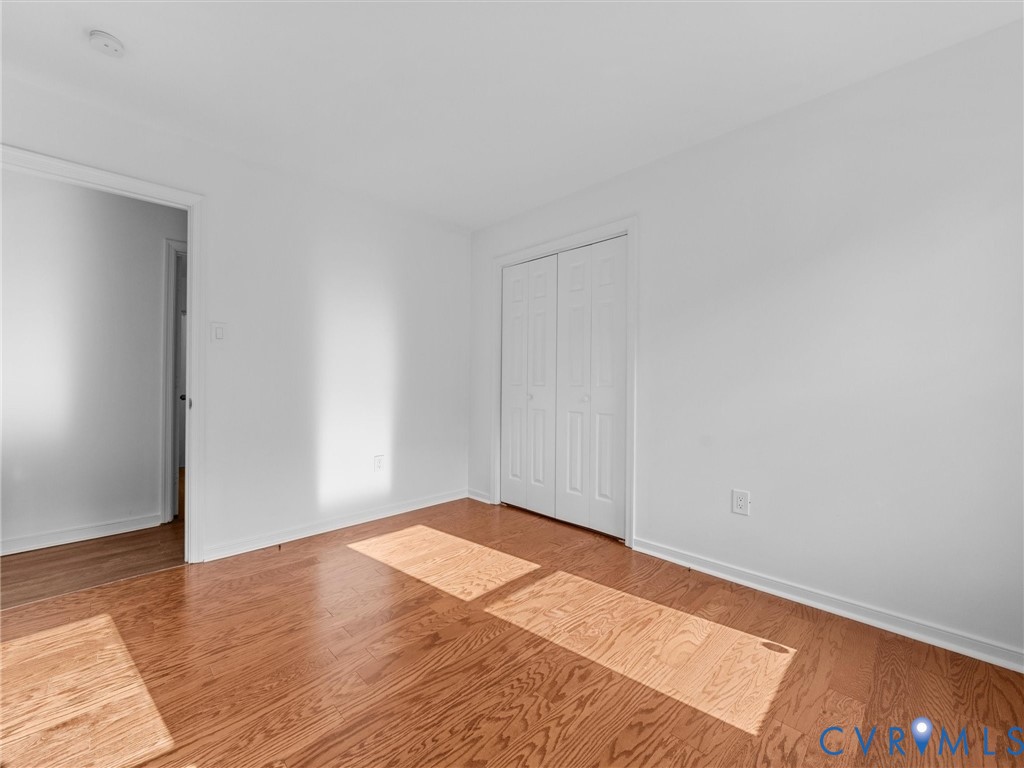 Neutral interior with wood-finish flooring and double-panel closet doors