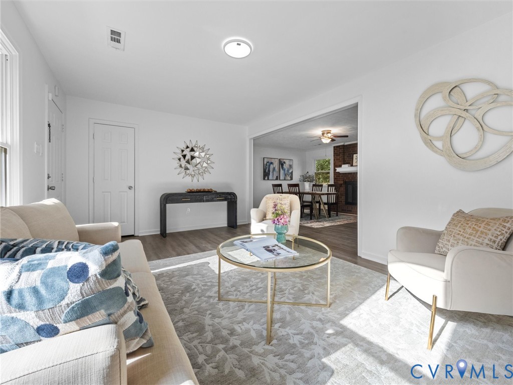 Neutral interior featuring wood-finish flooring, white walls, and a recessed brick fireplace surround Neutral interior featuring wood-finish flooring, white walls, and a recessed brick fireplace surround
