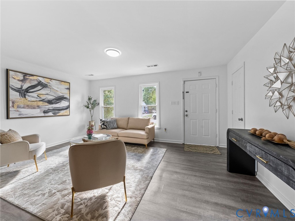 Neutral interior featuring wood-finish flooring, white walls, double-pane windows, and a flush-mount ceiling light fixture