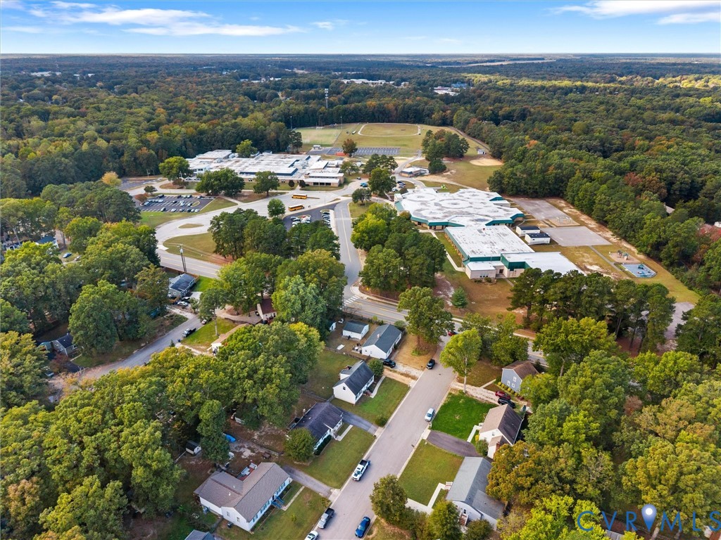 Aerial perspective featuring dense mature tree coverage, expansive green space, and established residential infrastructure