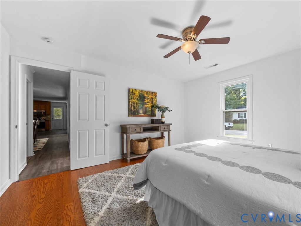 Interior space featuring hardwood flooring, multi-pane window, and ceiling-mounted light fixture with fan