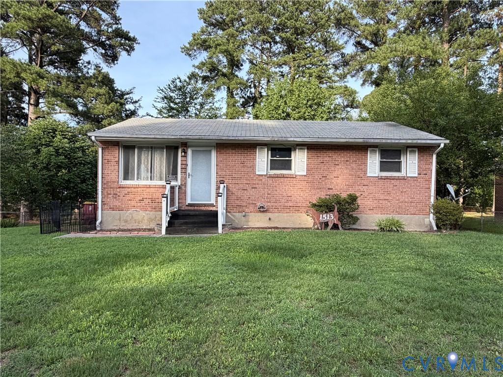 Ranch-style residence featuring a brick facade, asphalt shingle roof, white window shutters, and a front entrance with a metal railing Ranch-style residence featuring a brick facade, asphalt shingle roof, white window shutters, and a front entrance with a metal railing