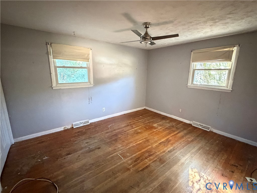 Wood-finish flooring, dual windows with built-in shades, and a ceiling-mounted light fixture