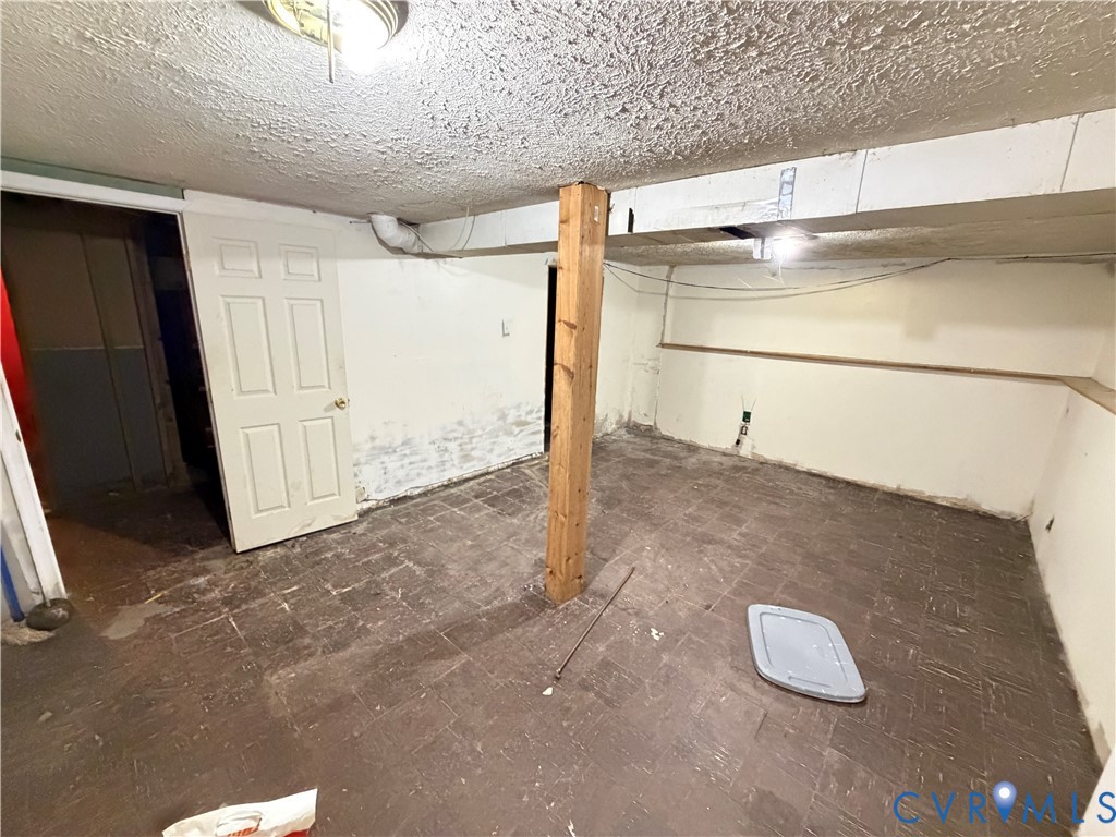Interior space featuring tile flooring, exposed structural wood post, and a paneled interior door