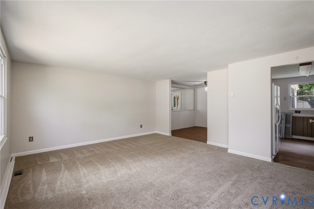 Neutral-toned wall paint, neutral carpeting, and multi-paned window