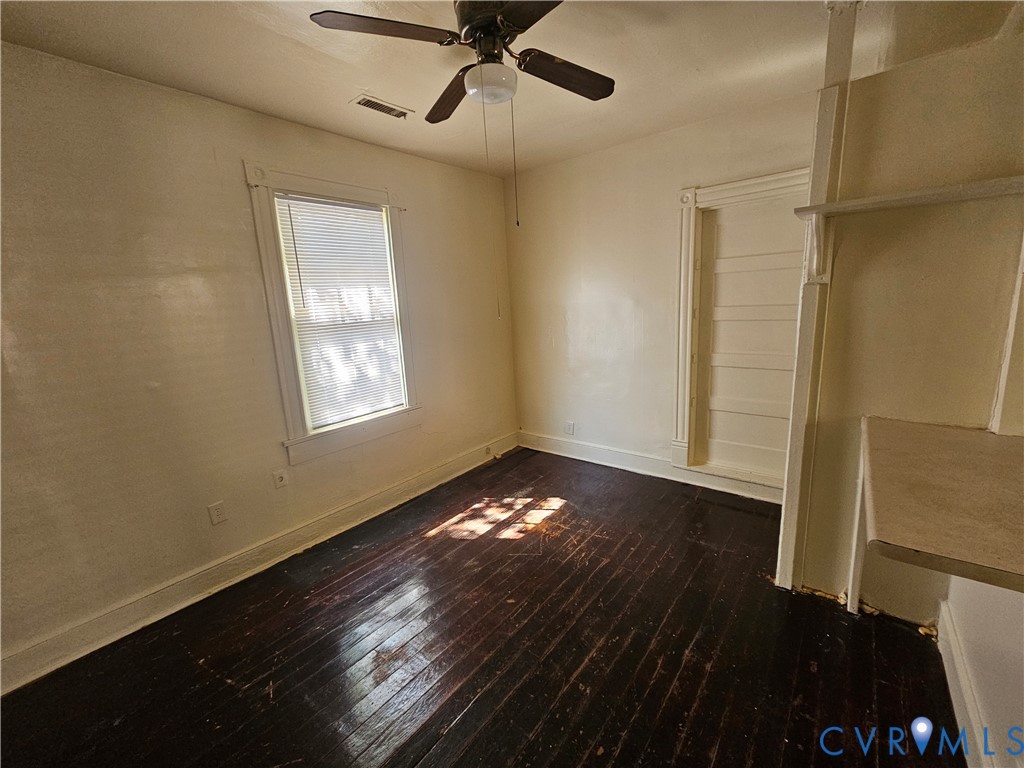 Wood-finish flooring, ceiling fan with integrated lighting, single-hung window with casing, and built-in shelving unit Wood-finish flooring, ceiling fan with integrated lighting, single-hung window with casing, and built-in shelving unit