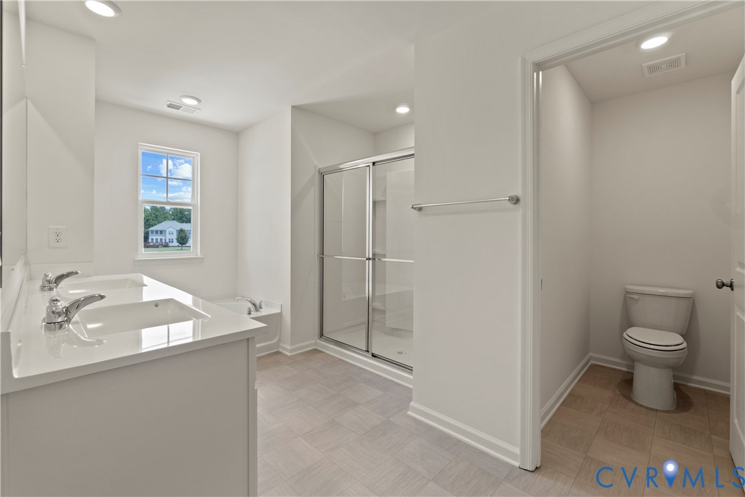 Bathroom featuring a dual vanity with undermount sinks, a quartz-look countertop, and chrome fixtures