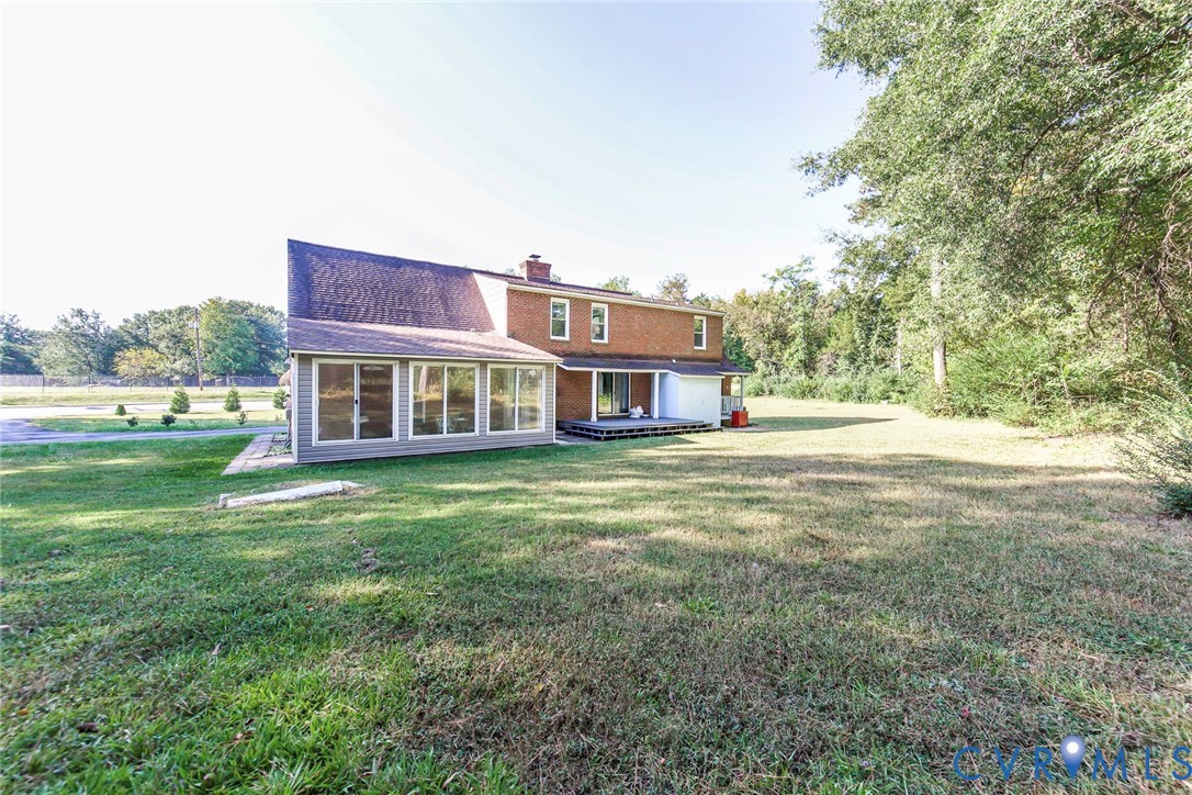 Exterior featuring a brick and siding facade, multi-pane sunroom, and wood deck Exterior featuring a brick and siding facade, multi-pane sunroom, and wood deck