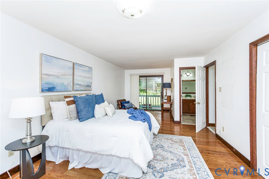 Wood-finish flooring, sliding glass door with exterior access, flush-mount ceiling lighting, and six-panel interior doors