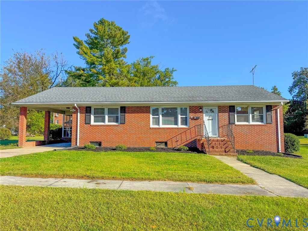Brick exterior, attached carport, asphalt shingle roof, multi-pane windows, and concrete front walkway Brick exterior, attached carport, asphalt shingle roof, multi-pane windows, and concrete front walkway