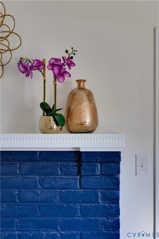 Painted brick fireplace surround with a white fluted crown molding mantel