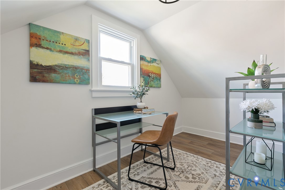 Vaulted ceilings, wood-finish flooring, and single-hung window with white casing