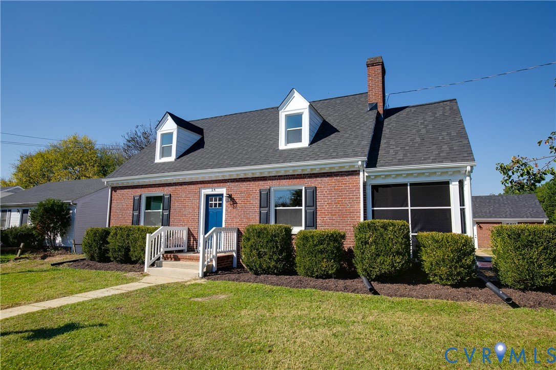 Classic brick exterior featuring two gabled dormers, a prominent masonry chimney, white shuttered windows, and a screened-in porch
