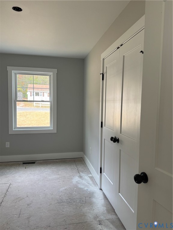 Neutral paint tones, double-panel closet doors with matte black hardware, and a window with muntin detailing