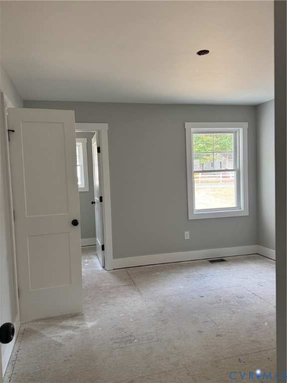 Neutral-toned interior walls, white-painted door frames and window casings, two-panel interior door, and single-hung window with muntins