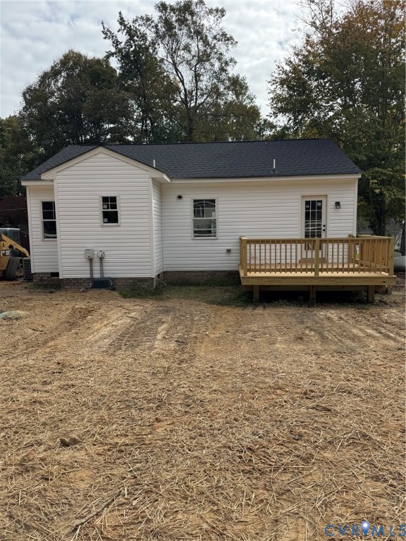 Exterior featuring white horizontal siding, a gabled roofline, and an elevated wood deck with perimeter railing
