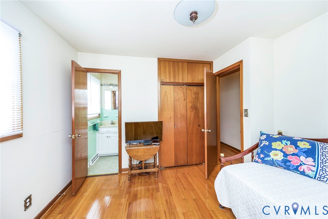 Hardwood flooring, built-in wooden closet cabinetry, and a central ceiling-mounted light fixture