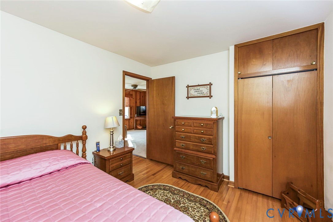 Wood-finish flooring, built-in floor-to-ceiling wooden cabinetry, and solid wood interior doors