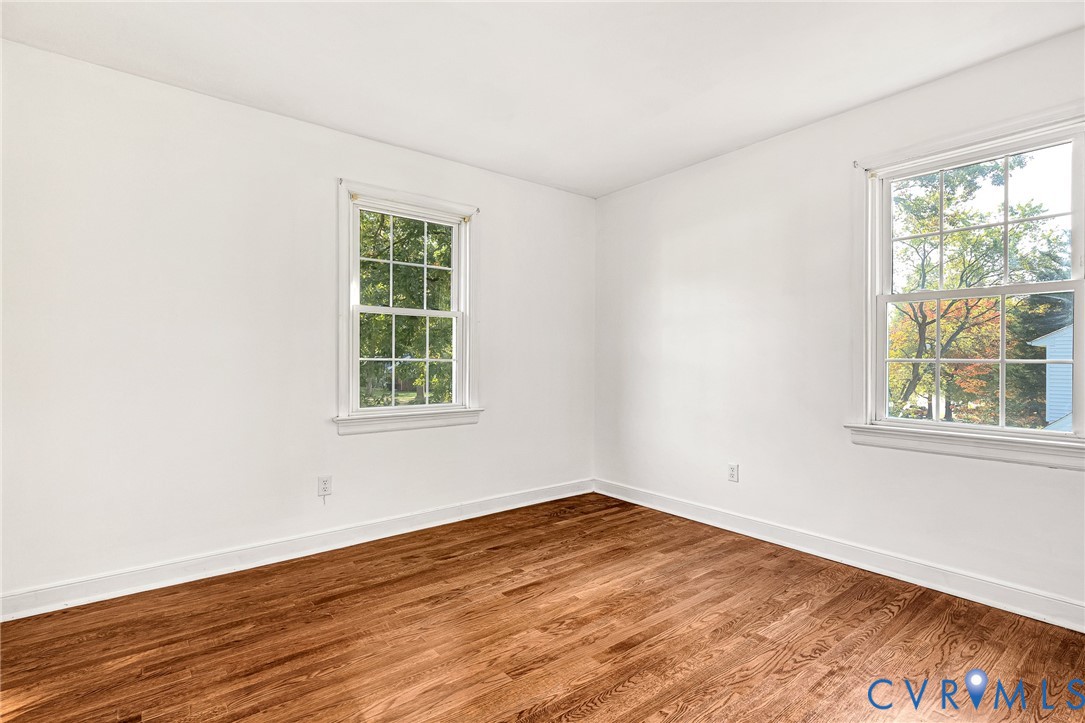 Interior room featuring wood-finish flooring, white walls, and multi-pane windows