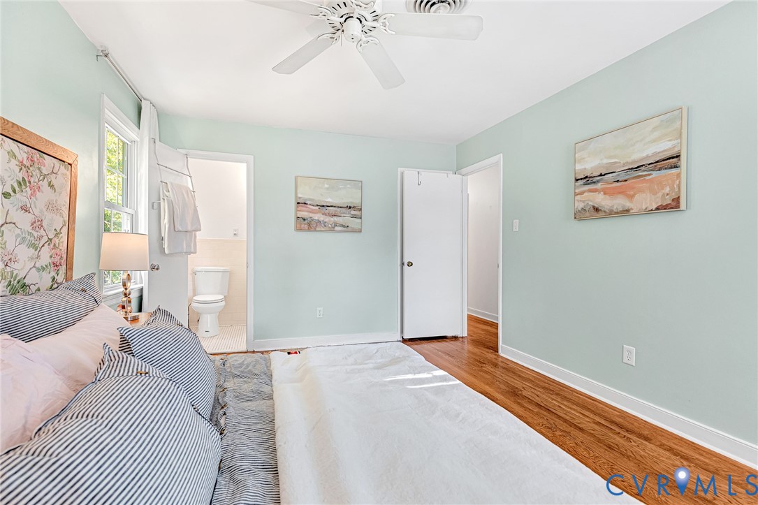 Bedroom featuring wood-finish flooring, a white ceiling fan, and a neutral color palette