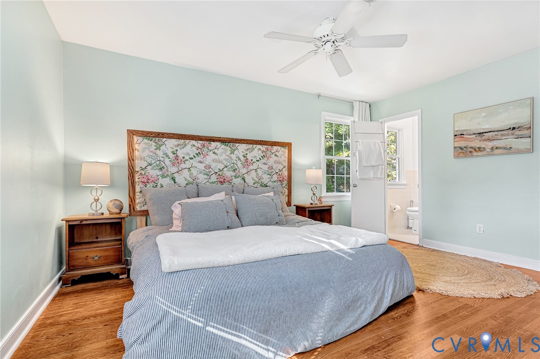 Room featuring wood-finish flooring, a white ceiling fan, and a multi-pane window