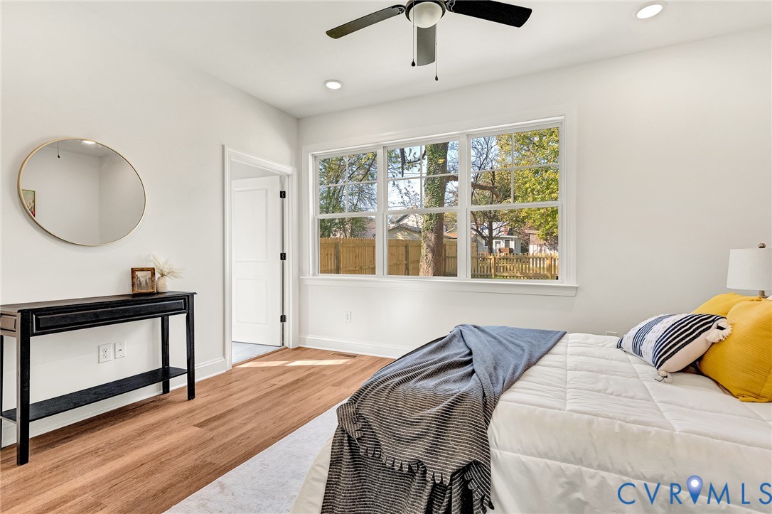 Wood-finish flooring, recessed lighting, multi-pane window, and a ceiling fan