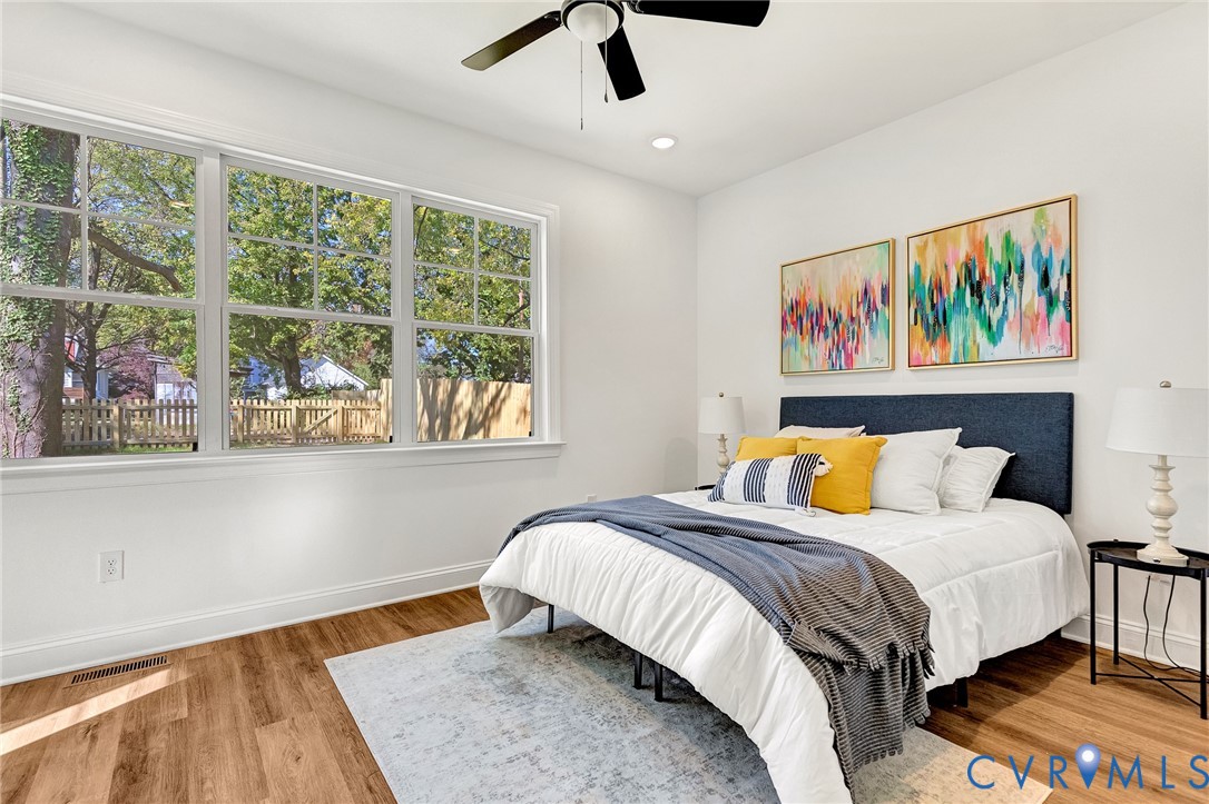 Large multi-pane window with wood-finish flooring, recessed lighting, and a ceiling-mounted fan
