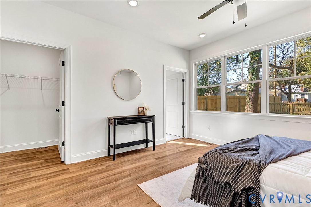 Wood-finish flooring, multi-pane windows, recessed lighting, ceiling fan, and wire-rack closet shelving