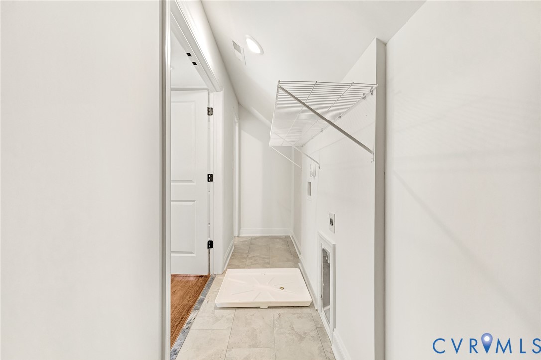 Utility space featuring tile flooring, white wall-mounted wire shelving, and recessed ceiling lighting