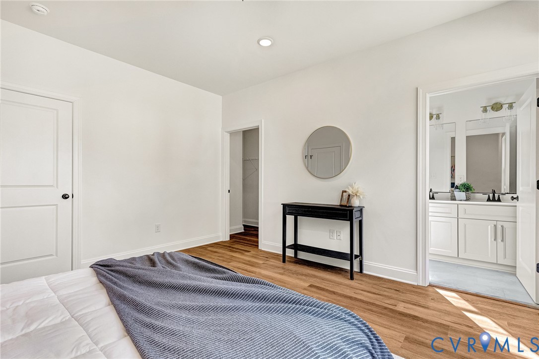 Room featuring wood-finish flooring, recessed lighting, and white interior doors