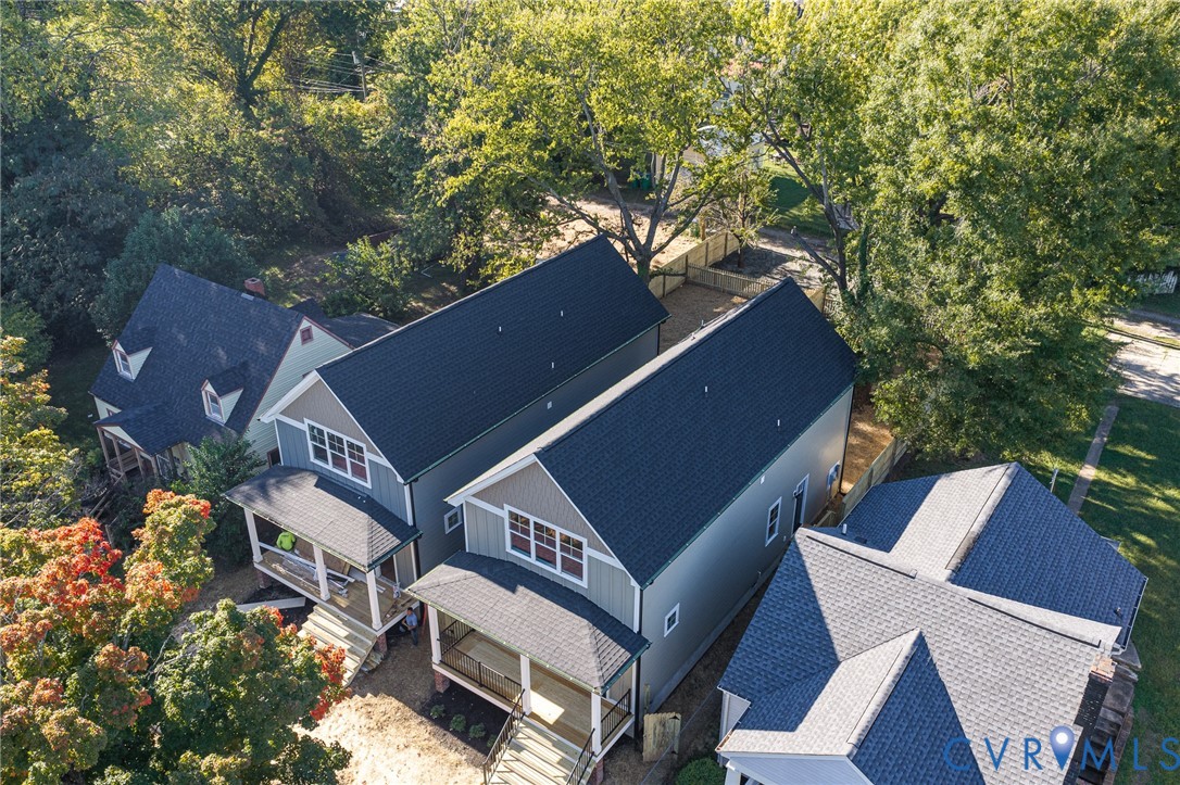 Gabled roof structures with dark shingles, multi-story siding exteriors, front-facing covered porches, and wood fencing