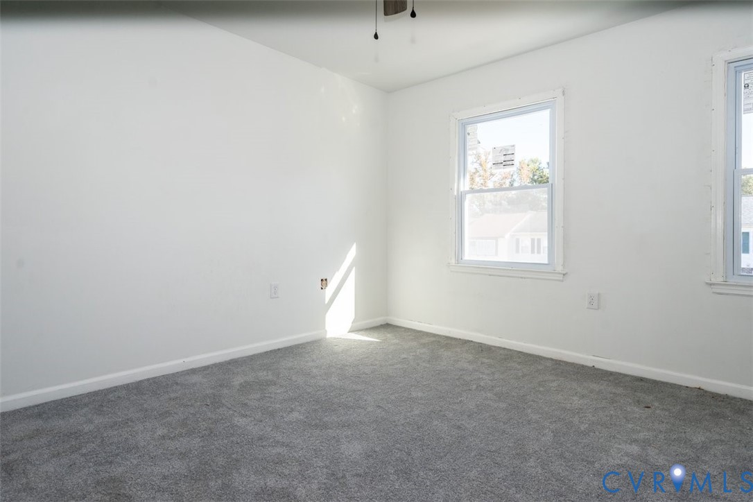 Neutral-toned wall-to-wall carpeting, crisp white wall finish, double-pane vinyl windows, and a ceiling-mounted light fixture Neutral-toned wall-to-wall carpeting, crisp white wall finish, double-pane vinyl windows, and a ceiling-mounted light fixture