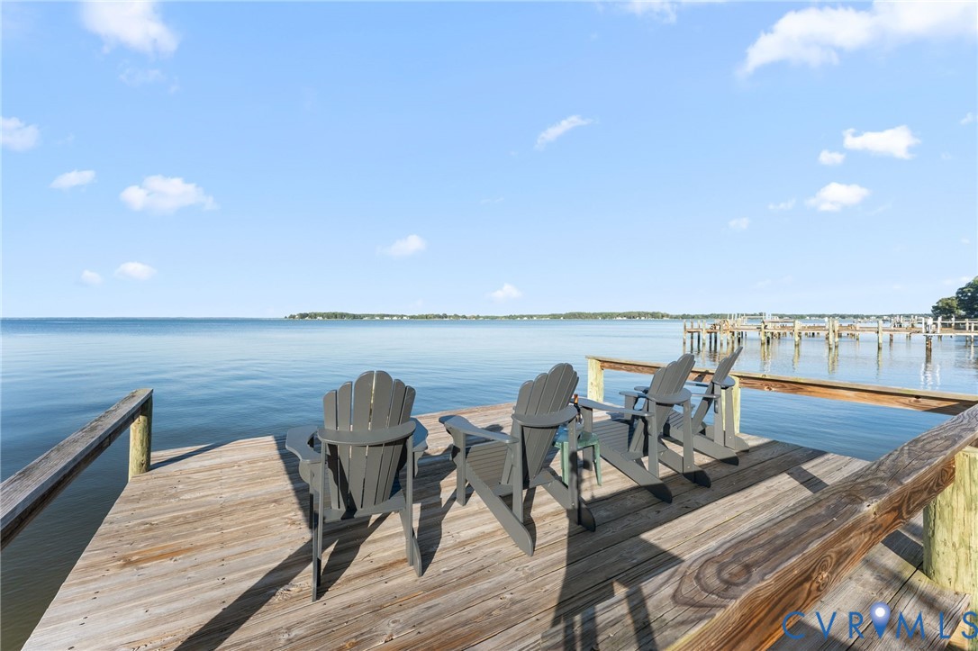 Waterfront wood deck featuring structural piling supports and wooden railings
