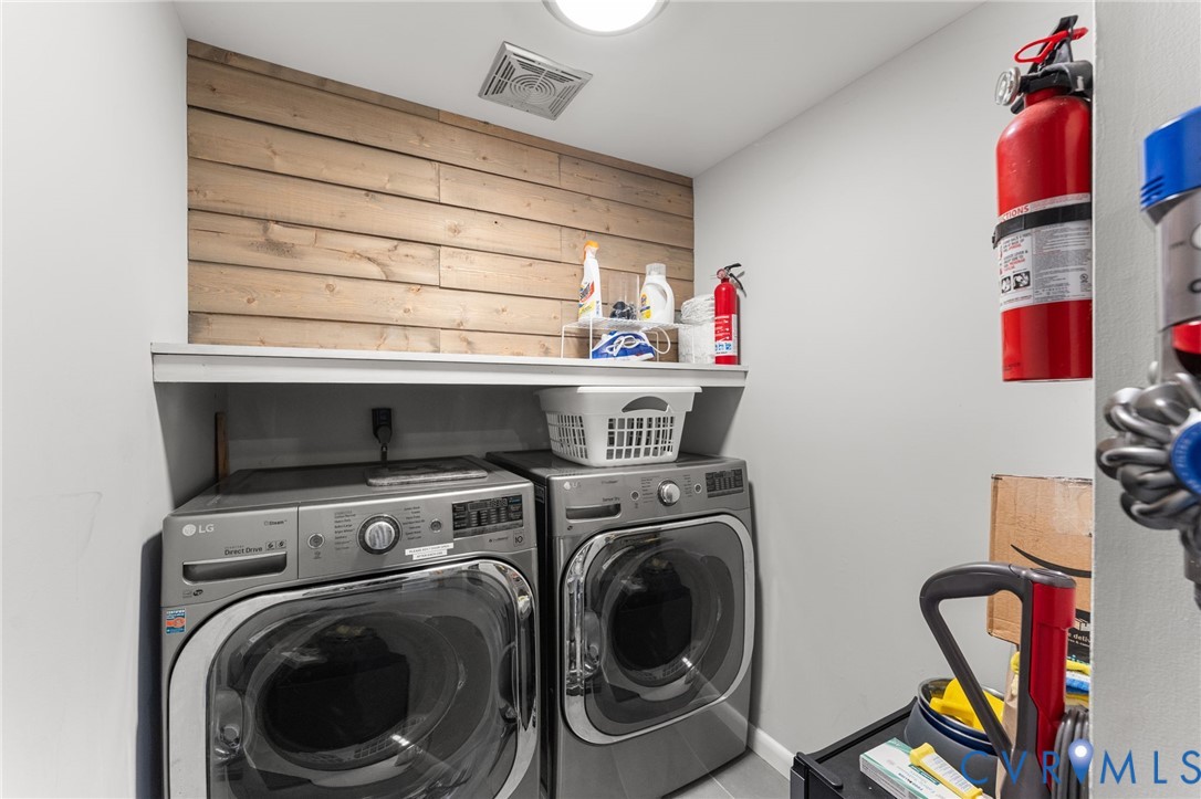 Laundry alcove featuring wood-plank accent walling and a built-in overhead shelf