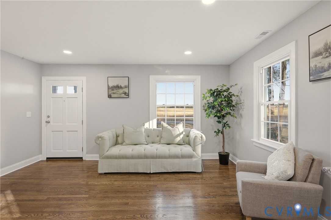 Neutral-toned walls, wood-finish flooring, recessed lighting, and multi-pane windows