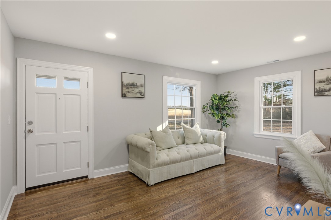 Neutral interior featuring wood-finish flooring, recessed lighting, multi-pane windows, and a six-panel exterior door with glass inserts