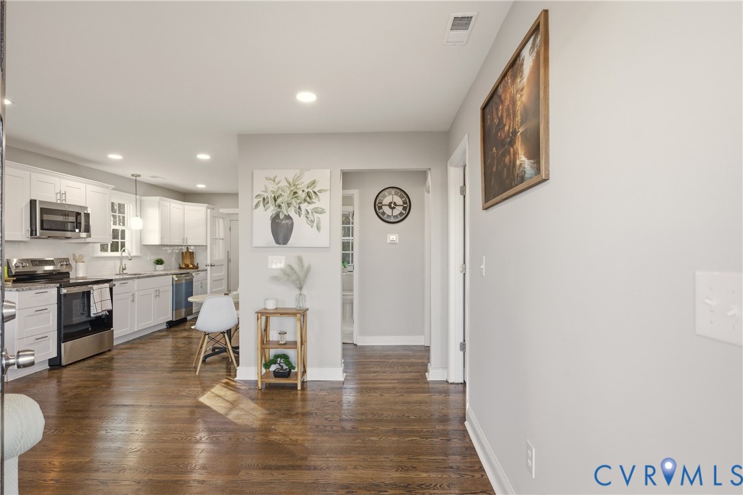 Kitchen featuring white cabinetry, wood-finish flooring, recessed lighting, and stainless steel appliances