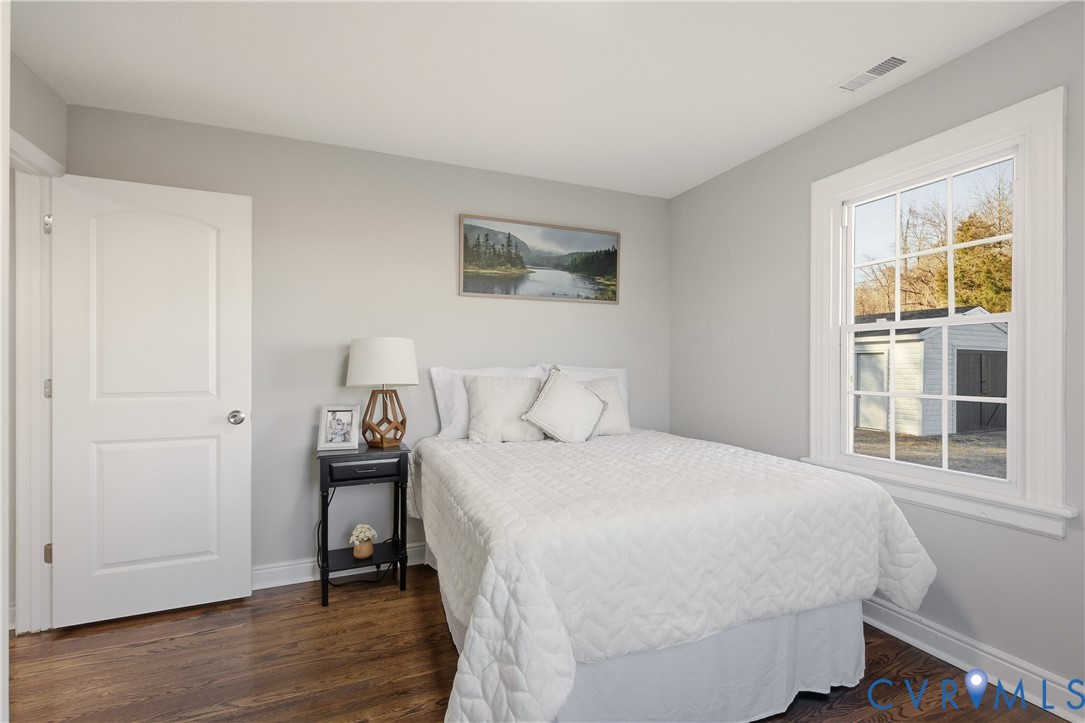 Room featuring wood-finish flooring, a multi-pane window with white trim, and a paneled interior door