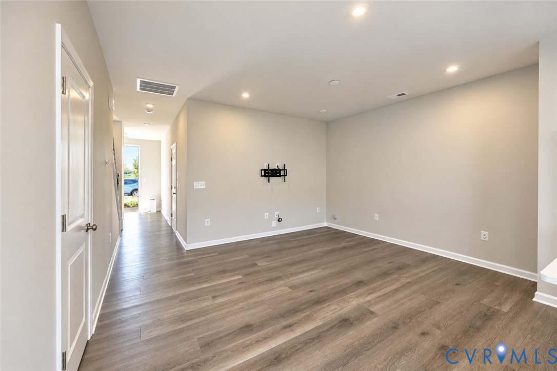 Interior space featuring wood-finish flooring, neutral wall tones, and recessed lighting