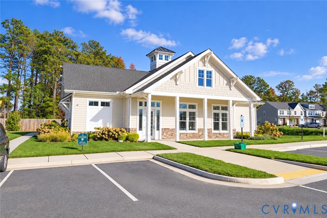 Craftsman-style exterior featuring horizontal lap siding, shake-shingle accents, a stone veneer base, a roof-mounted cupola, and a covered front porch