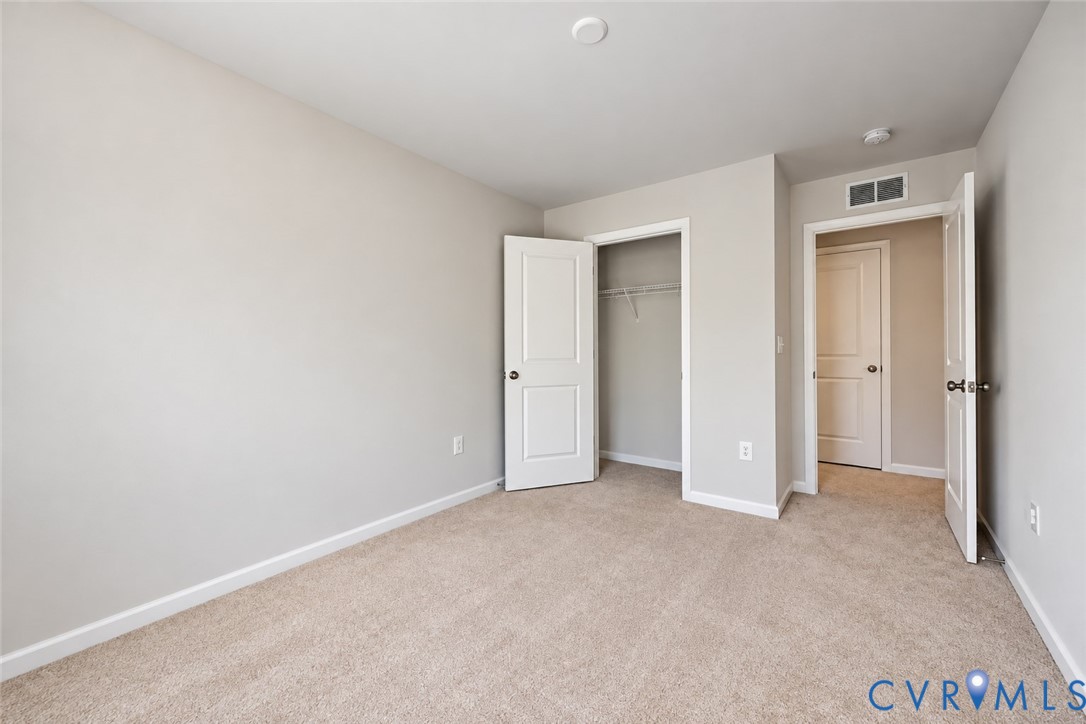 Neutral-toned walls, wall-to-wall carpeting, and interior doors with paneled detailing